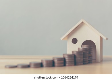 Property Investment And House Mortgage Financial Concept, Money Coin Stack With Wooden House