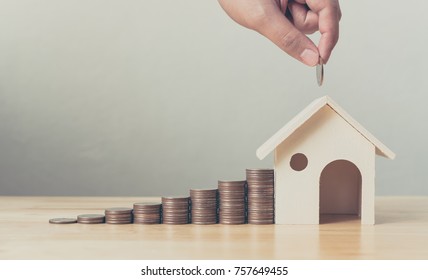 Property investment and house mortgage financial concept, Hand putting money coin stack with wooden house - Shutterstock ID 757649455