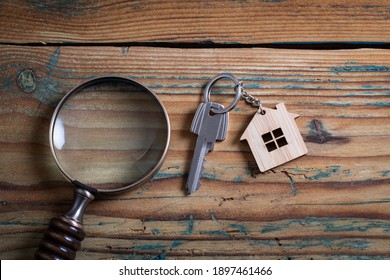 Property Key And Magnifying Glass On Wooden Table. Market Research, Supply And Demand Concept