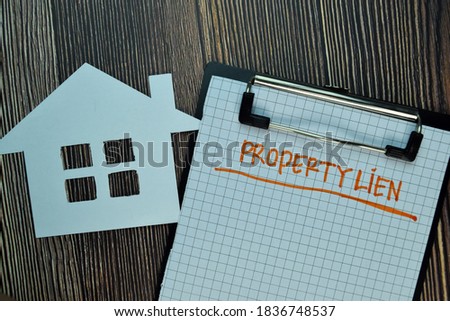 Property Lien write on a paperwork isolated on Wooden Table. Business or Financial Concept