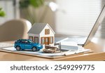 property, real estate, financial, loan, wealth, investment, construction, estate, insurance, residential. A blue car is on a table next to a house. The car is a toy and the house is a model.