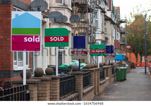 Property Sales. Estate Agents Sold Signs on UK\
Terraced Houses