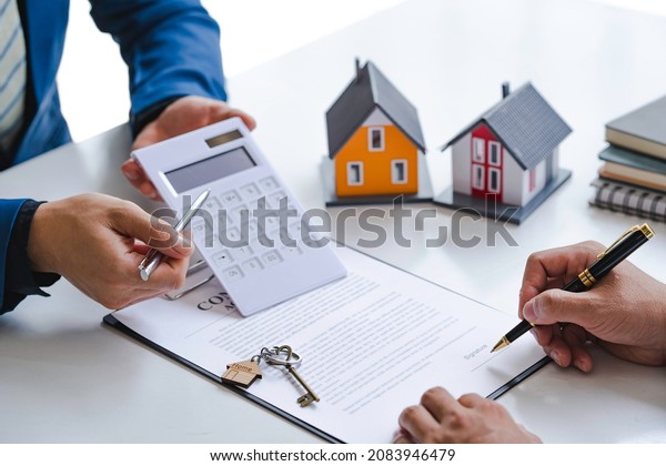 Property sales staff submit land\
mortgage contract documents to home buyers for a sign. Business\
contract, lease, purchase, mortgage, loan or home insurance\
documents