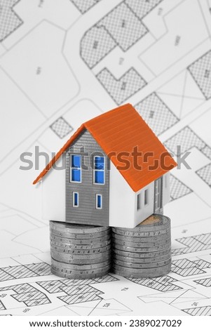 Property Tax on buildings - Property Real Estate concept with a small home model and euro coins group - Growth in property value concept