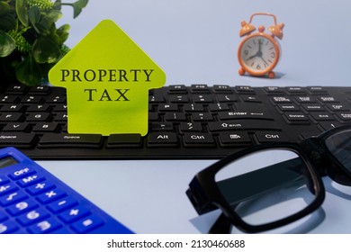 Property Tax Text On Yellow Paper With Stationery On A Desk. Real Estate Property Tax And Investment Concept.