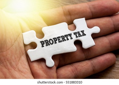 PROPERTY TAX written on White color of jigsaw puzzle with hand,conceptual - Shutterstock ID 551883310