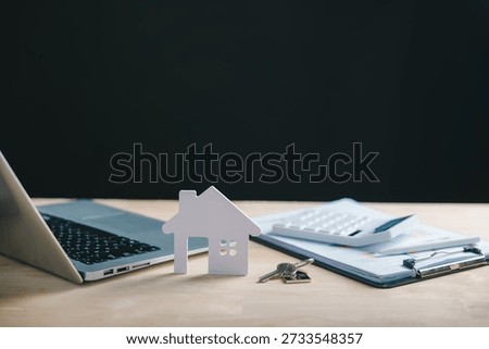 Property value assessment using laptop computer paper house model real estate keys financial data calculator for business mortgage loan market price increase.