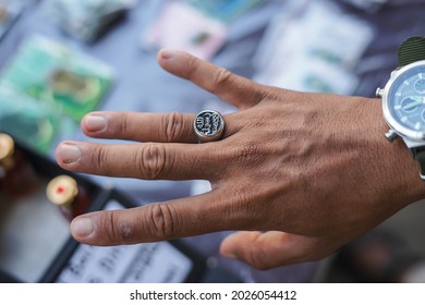 The prophet muhammad ring was silver and black. It's in the hands of a Muslim man with the blur's background.