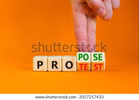 Propose instead protest symbol. Businessman turns wooden cubes, changes the word 'protest' to 'propose'. Beautiful orange table, orange background. Business, protest or propose concept. Copy space.