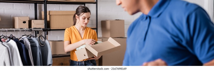 Proprietor Holding Box With Clothes Near Blurred African American Deliveryman In Online Web Store, Banner