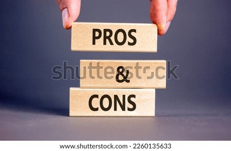 Pros and cons symbol. Wooden blocks with words 'Pros and cons'. Beautiful grey background, businessman hand. Business, pros and cons concept, copy space.
