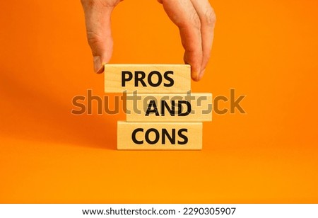 Pros and cons symbol. Wooden blocks with words 'Pros and cons'. Beautiful orange background, businessman hand. Business, pros and cons concept, copy space.