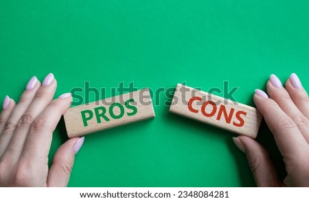 Pros vs Cons symbol. Concept word Pros vs Cons on wooden blocks. Businessman hand. Beautiful green background. Business and Pros vs Cons concept. Copy space. Concept word