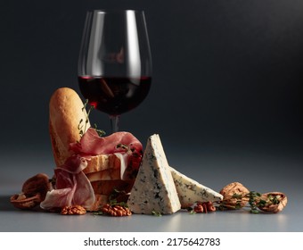 Prosciutto with blue cheese, red wine, baguette, walnuts, and thyme. Red wine with traditional Mediterranean snacks. - Powered by Shutterstock