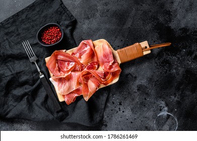 prosciutto crudo, italian salami, parma ham. Antipasto plate. Black background, top view, space for text