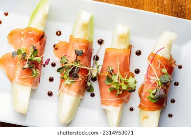 Prosciutto and Melon. Charcuterie platter. Assortment on cured and salted deli meats and cheeses, pastrami, salami, prosciutto served with olives and fruits. Classic traditional party favorite.   - Shutterstock ID 2314953071