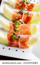 Prosciutto and Melon. Charcuterie platter. Assortment on cured and salted deli meats and cheeses, pastrami, salami, prosciutto served with olives and fruits. Classic traditional party favorite.   - Shutterstock ID 2314953081