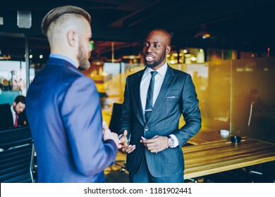 Prosperous African American Executive Manager Meeting Male Sponsor For Discussing Details Of Cooperation, Confident Businessman In Formal Suits Talking To Each Other About Economic Information