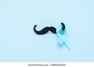 prostate cancer awareness, blue ribbon with black mustache on blue background - Powered by Shutterstock