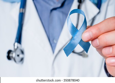 Prostate Cancer Awareness. Blue Ribbon In Doctor Hand. Man, Male Support, Care, Charity. Concept Of Medicine Oncology Closeup Sky Symbol. Carcinoma, Achalasia Help. Middle Age Person.