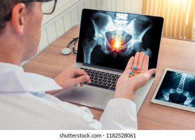 Prostate Cancer Concept Treatment Or Prevention. Doctor Holding Pills For Illness With Xray On The Laptop And Digital Tablet 