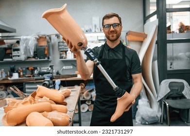 With prosthesis in hands. Technician working with prosthesis in modern laboratory. - Powered by Shutterstock