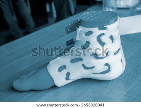 Prosthesis printed on a 3D printer from molten plastic on a plastic foot. Prototype of medical prosthesis for foot created on 3D printer. Medical orthosis, fixator, splint corset langet from plastic