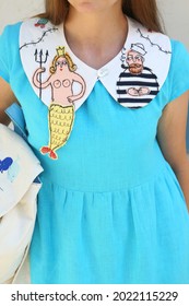 PROTARAS, CYPRUS - AUGUST 2, 2021: Russian Fashion Woman In Handmade Embroiderad Collar, Blue Dress. Street Style. Stylish Look, Fashionable Summer Outfit. Fashion Girl In Collar With Mermaid, Dress