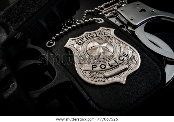 Protect and serve, crime fighting and blue lives\
matter concept with a police badge, a gun and a pair of handcuffs\
at night