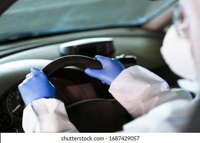 Protect Yourself. Person In Coronavirus Hazmat, Gloves And Face Mask Driving A Car, Coronavirus Epidemic, World Pandemic