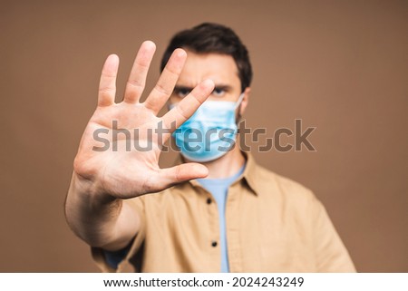Protection against contagious disease, coronavirus, covid-19. Man wearing hygienic mask to prevent infection, airborne respiratory illness such as flu, 2019-nCoV. Isolated over beige background