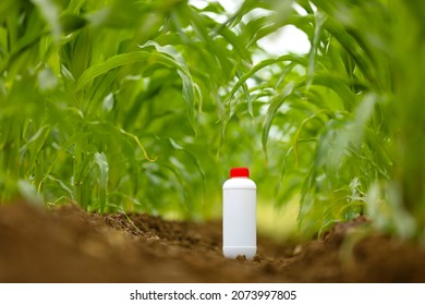 Protection Of Crops From Pests And Diseases. Pesticide Bottle At Agriculture Field.