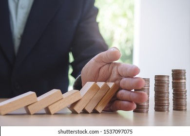 Protection Finance From Domino Effect Concept. Hands Stop Domino Effect Before Destroy Stack Of Money.