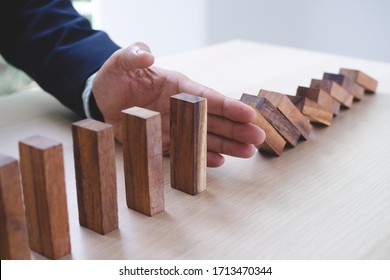 Protection finance from domino effect concept. Hands stop domino effect before destroy stack of money. - Shutterstock ID 1713470344