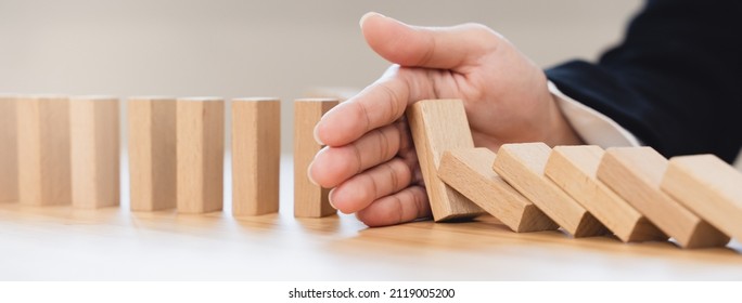 Protection Finance From Domino Effect Concept. Hands Stop Domino Effect Before Destroy Stack Of Money.