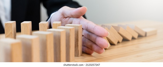 Protection Finance From Domino Effect Concept. Hands Stop Domino Effect Before Destroy Stack Of Money.