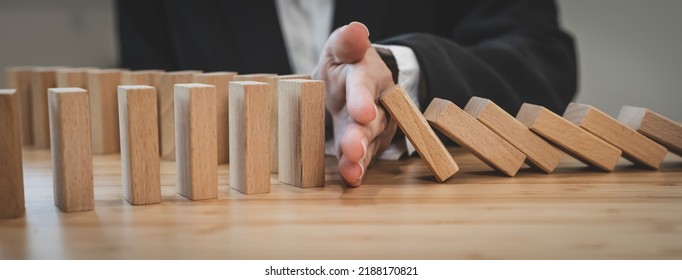 Protection Finance From Domino Effect Concept. Hands Stop Domino Effect Before Destroy Stack Of Money.