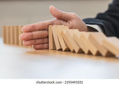 Protection Finance From Domino Effect Concept. Hands Stop Domino Effect Before Destroy Stack Of Money.