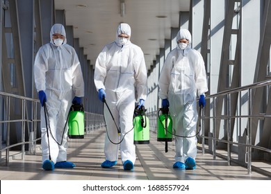 Protection measures by specialists in coronavirus hazmat suits with spray chemicals, copy space - Shutterstock ID 1688557924