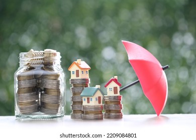 Protection, Model house on stack of coins money with the umbrella on nature green background,Finance insurance and Safe investment concep