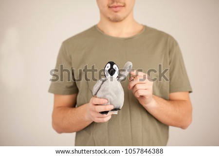Protection Nature. Male hands close-up holds the symbol concept. Cute penguin waving fin. protects all animals and mammals. Indifferent people in their palms Irrelevant, frivolous actions in ecosystem
