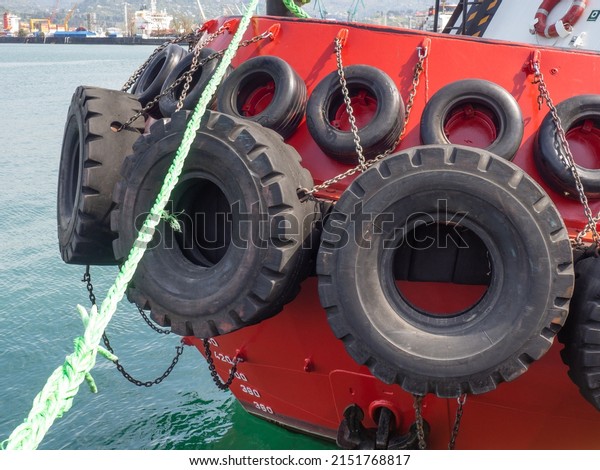 Protection of the side of the ship with car
tires. Moored ship. Portholes in the hold. Ship at the pier.
Equipment in the port. Board of the
ship

