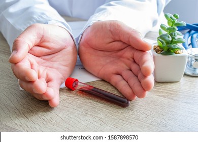 Protection, treatment, prevention and patronage health in hematology in blood health against diseases, pathologies, oncology concept photo. Doctor surrounded lab tube with blood with hands on desk