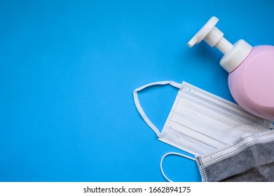 Protective Face Mask And Hand Cleansing Soap And Alcohol Gel On Blue Background Concept For Prevent And Protect Coronavirus Covid-19