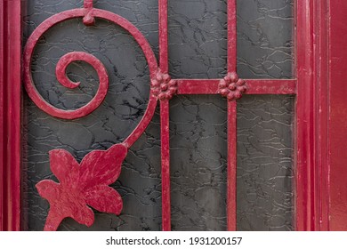 Protective forged elements of the door of a private house in the old style, red
