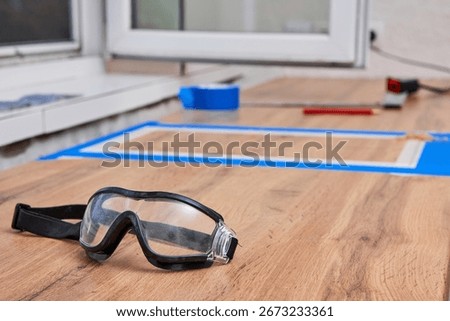 protective glasses lying on kitchen countertops, marking cutting hole for the sink, renovation, copy space