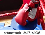 Protective gloves in corner of boxing ring. Space for text