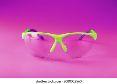 Protective Open Glasses Isolated On A Pink Background. Reliable Eye Protection, Free Space