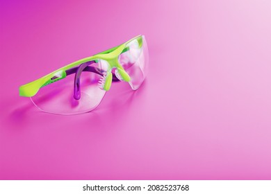 Protective Open Glasses Isolated On A Pink Background. Reliable Eye Protection, Free Space