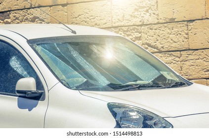 Protective Reflective Surface Under The Windshield Of The Passenger White Car Parked On A Hot Day, Sun Rays Protection And Heating Vehicle Interior